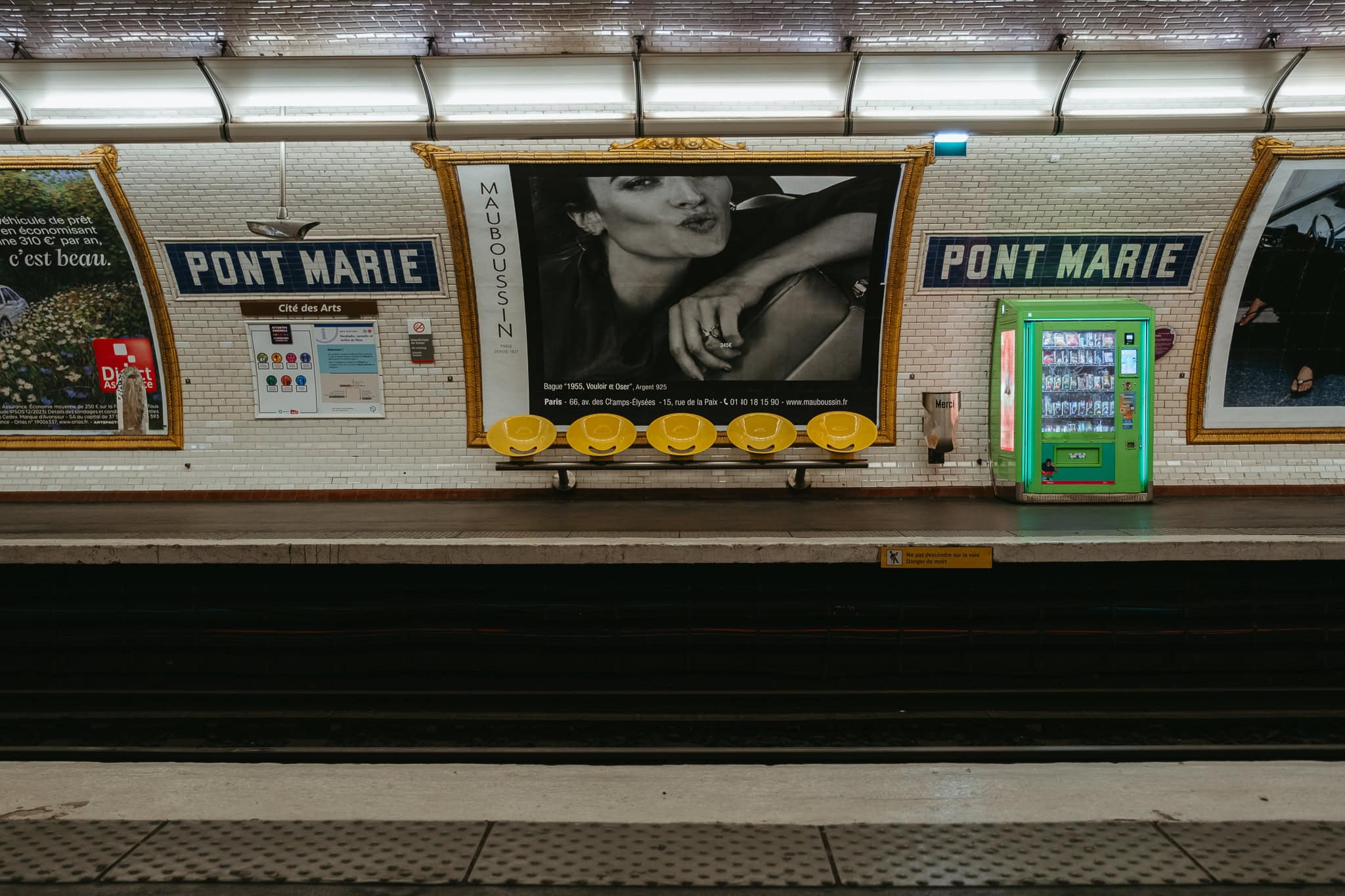 Seats and advertisements inside Paris's Pont Marie metro stop.