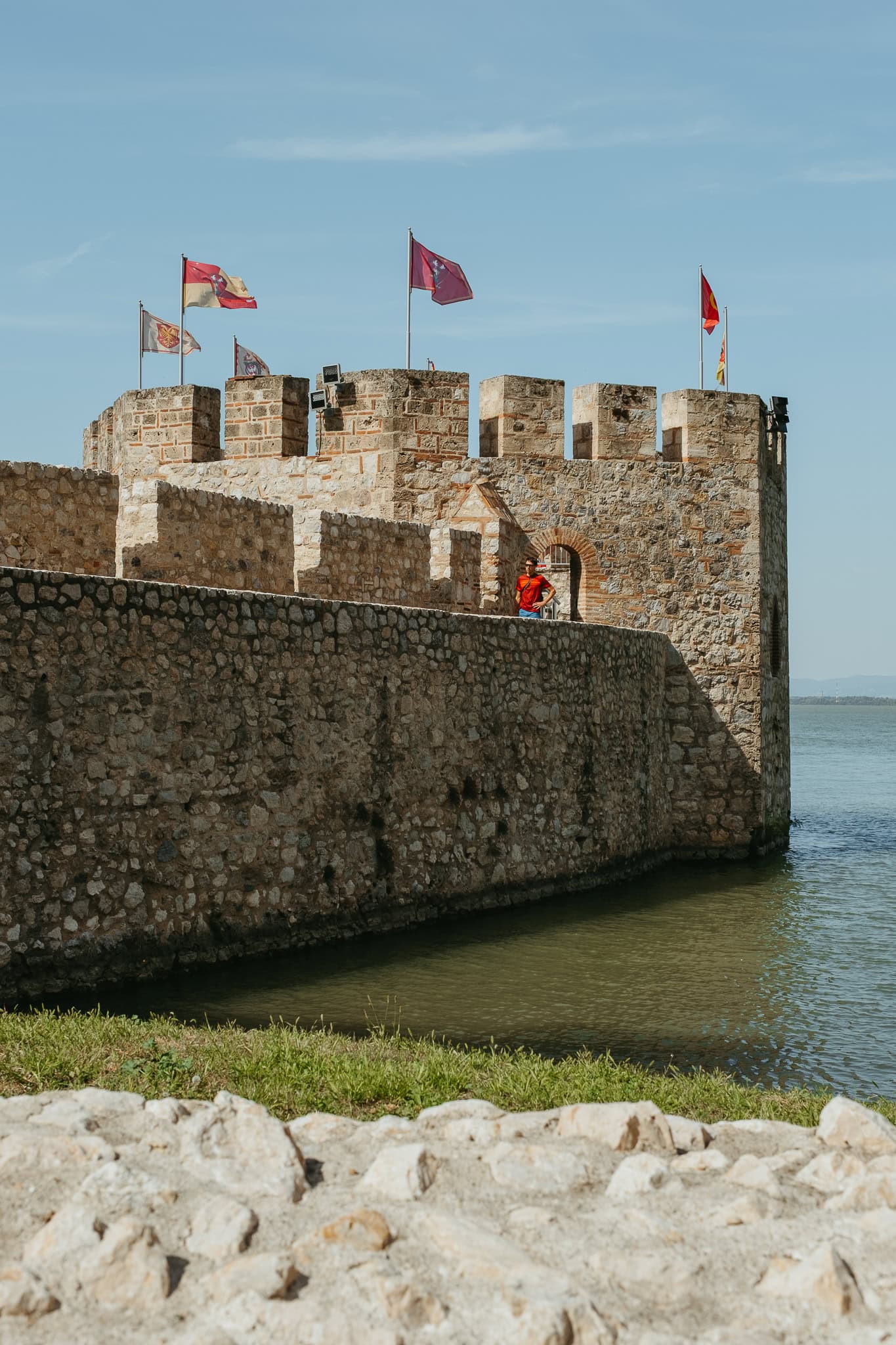 A fortress tower extends into a river.