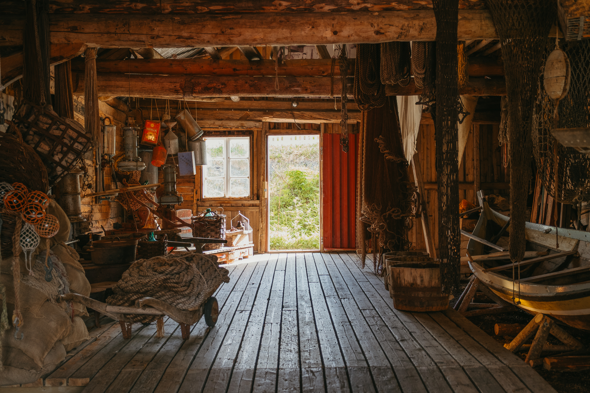 Inside a restored boathouse with a boat and fishing nets.