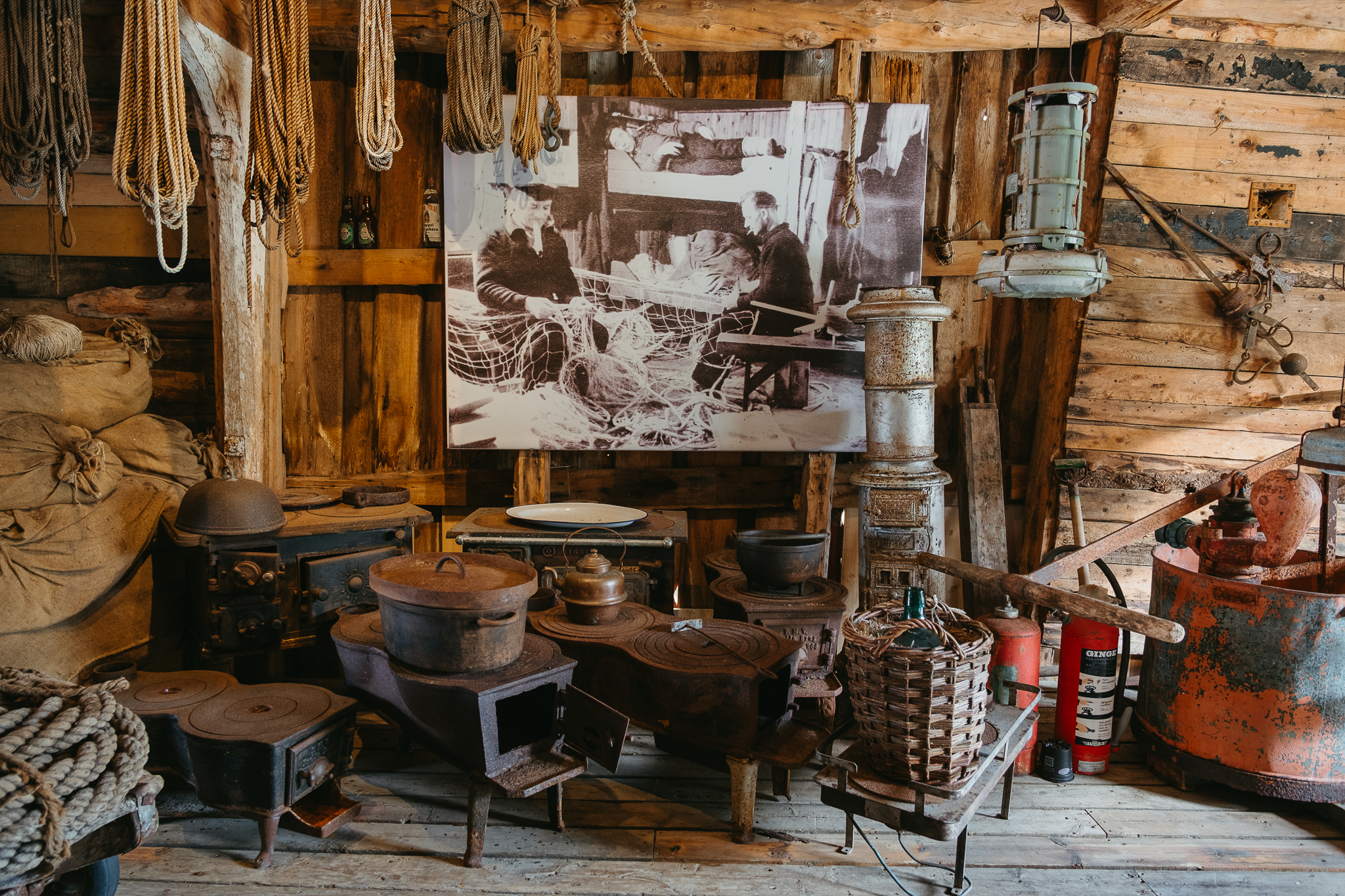 A building with a display of antique equipment and a photo of people making fishing nets.